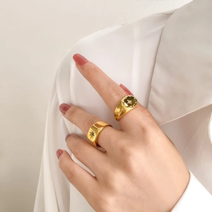 Gold plated signet rings with sparkling starburst zircon inlay worn by model