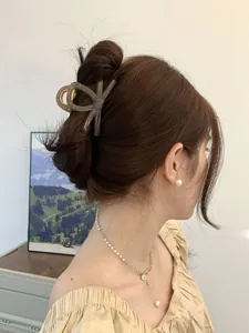 Brown bow hair claw clip showing a half-up hairstyle with elegant acrylic finish