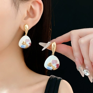 Close-up of vintage floral earrings with colorful enamel petals and gold plating