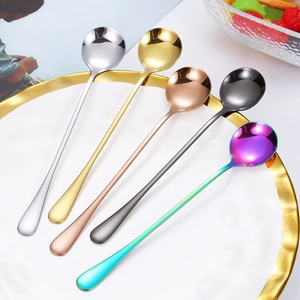 Set of five colorful stainless steel long handle coffee and dessert spoons on a plate