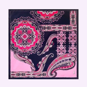 Detailed view of square silk scarf with navy paisley and medallion floral patterns