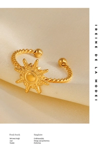 Macro detail of 18K gold plated sun starburst ring on silk with twisted rope texture