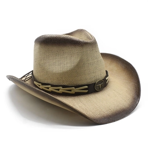 Detail of western straw cowboy hat with gradient brim and metallic bull head emblem