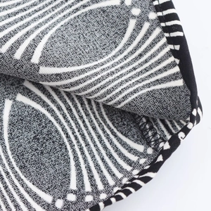 Close-up of geometric pattern blouse fabric with premium stitching and hemming detail