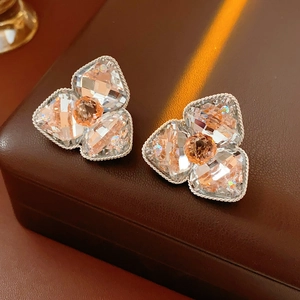 Close-up of diamond-encrusted flower earrings with champagne crystal and silver plating