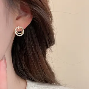 Close-up of elegant gold smiling face earrings with shimmering zircon pave setting