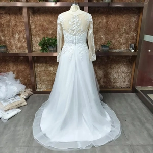 Detail of white V-neck wedding dress with lace illusion back and elegant row of buttons