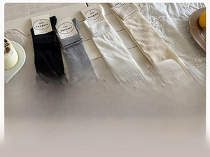 Detail view of cotton ballet style leg warmers with vertical ribs and ribbon bows