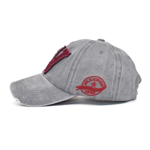 Detail view of washed cotton baseball cap with red patch and side wild jokers embroidery