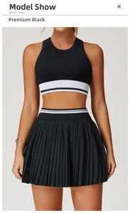 Πρόσοψη του μαύρου αθλητικού σετ με crop top και πλισέ φούστα γιόγκα για γυναίκες