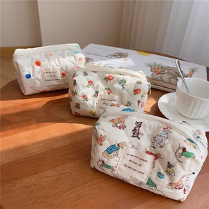 Detailed view of three quilted cotton makeup bags with floral and polka dot patterns