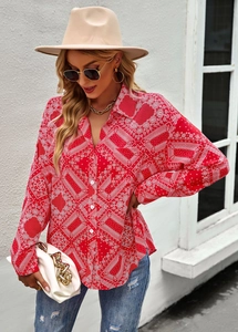 Street style shot of woman in red paisley print long sleeve shirt with blue jeans