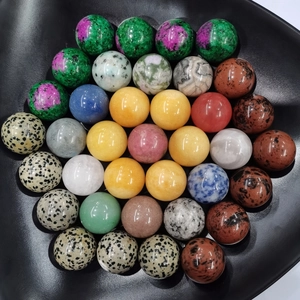 Overhead shot of 26 assorted 25mm natural crystal spheres in a black display bowl