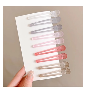 Set of 9 translucent matte hair clips in gradient colors from clear to brown on a card