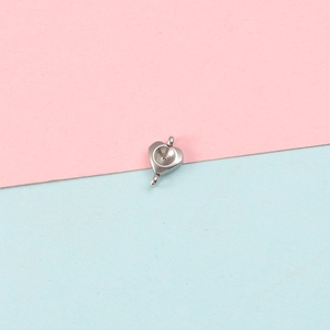 Close-up of heart-shaped stainless steel pendant base with double holes for DIY jewelry