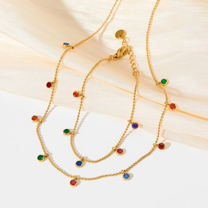 Detailed close-up of golden stainless steel jewelry set featuring colorful zircon tassels