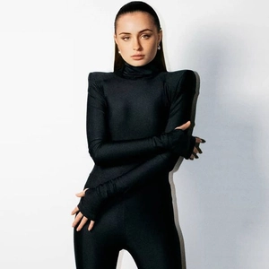 Detail of black high neck bodysuit featuring sharp shoulder pads and slim fit design