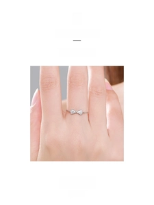 Detail shot of a silver bow ring with micro-pave zircons and flexible chain band