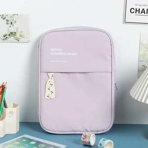 Lavender fabric laptop sleeve with cherry ribbon and text shown in a cozy desk setup