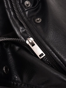 Close-up of metal zipper and silver snap button on black faux leather bomber jacket