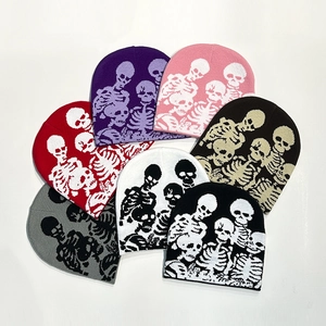 Detailed view of knitted beanies featuring skull patterns in multiple vibrant color options