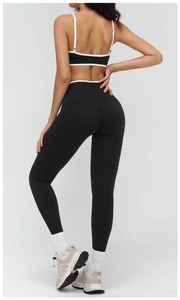 Detailed back view of high-waisted yoga leggings and sports bra with white piping detail