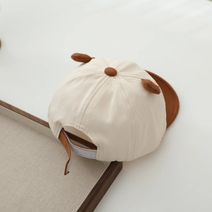 Detail of baby cartoon cap featuring cute 3D ears and adjustable velcro strap