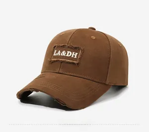 Detail of dark brown vintage baseball cap with LA&DH embroidery and distressed torn edges