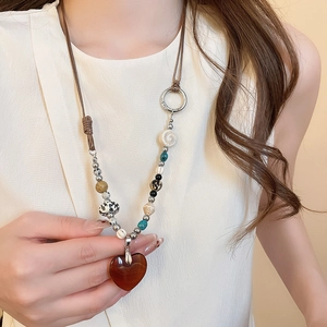 Close-up of heart-shaped stone pendant necklace with multicolor beads on a model