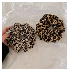 Detail showing two leopard print fabric scrunchies in light and dark patterns