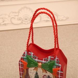 Detail of red Christmas lantern music box with green plaid patterns and a festive bow