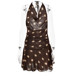 Close-up detail of brown polka dot fabric and ruched design on the halter neck dress