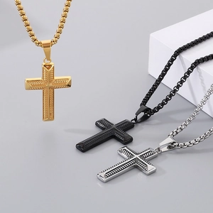 Detailed view of cross pendants on box chains in gold, black, and silver stainless steel