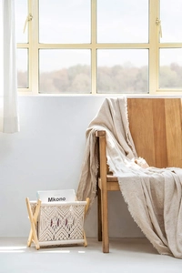 Close-up of bohemian hand-woven cotton rope texture on a foldable wooden magazine rack