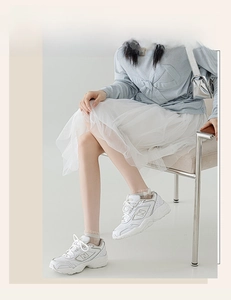Detailed view of white platform sneakers with mesh panels and silver N logo