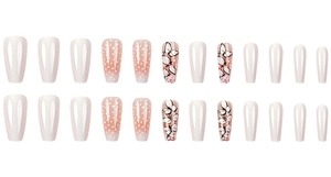 Flat lay of 24 coffin-shaped fake nails featuring white, polka dot, and butterfly designs