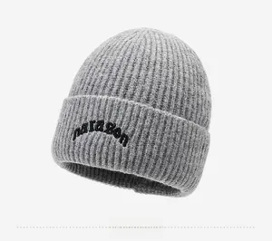 Close-up of gray knit beanie featuring black paragon embroidery and ribbed texture