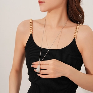 Detail of silver woven bottle pendant necklace with pave stones on a black knit top