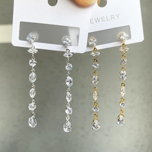 Detailed view of silver and gold teardrop tassel earrings with sparkling cubic zirconia crystals