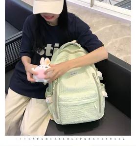 Détail du sac à dos matelassé vert menthe avec tissu texturé et étiquette tissée blanche