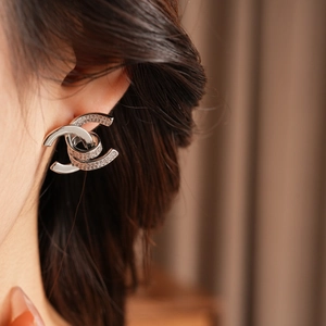 Close-up of interlocking double C earrings with paved cubic zirconia in a silver finish