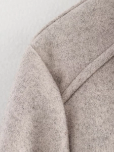 Macro detail of high-quality wool blend fabric and shoulder seam on a grey jacket