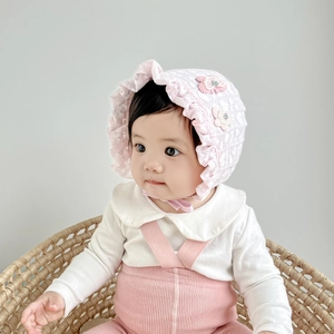 Detail of pink and white lace baby sun hat with floral applique and soft chin strap