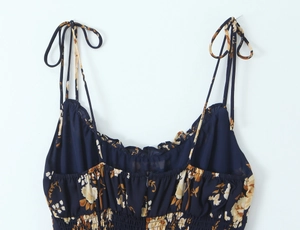 Detail of adjustable strap and ruffle neckline on a navy floral chiffon dress