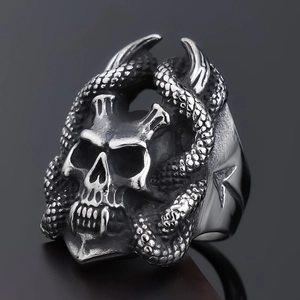 Detailed macro view of vintage stainless steel skull and snake ring with gothic texture