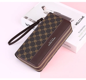 Detail of a brown double zipper long wallet for women with golden floral patterns