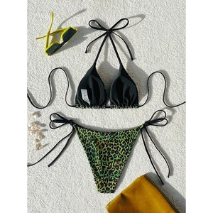 Flat lay of a leopard print bikini set with black halter top and side-tie bottoms
