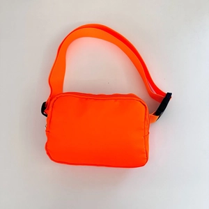 Detail view of the durable fluorescent orange nylon crossbody bag with adjustable strap