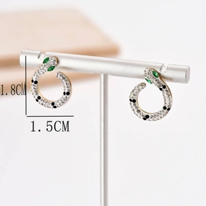 Golden snake-shaped C earrings with cubic zirconia, green stones and black accents