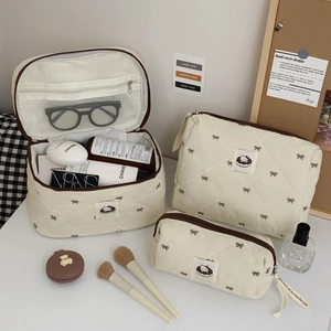 Three-piece beige quilted makeup bag set featuring cute cat patch and brown bows